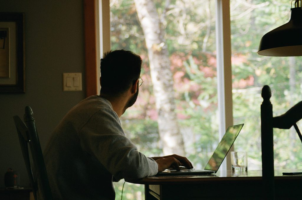man looking out window effective strategies to engage remote employees blog by wishlist